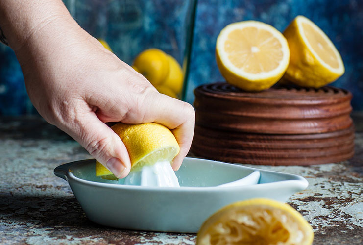 Hand squeezing lemons making lemonade